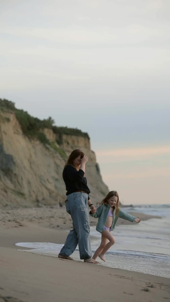 SweetPea Universe: mother and daughter hold hands and twirl on a beach, then Princess SweetPea pink bunny lovey appears.